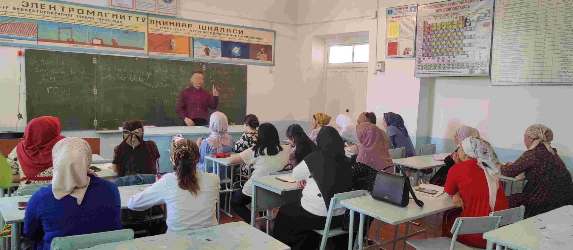 Women seated in a village classroom during a teaching session